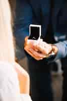 Free photo male hands with red velvet box containing engagement ring