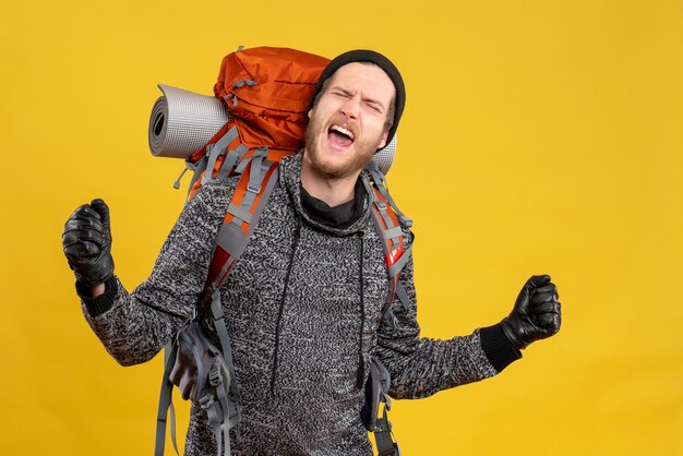 male hitchhiker with leather gloves and backpack expressing his feelings