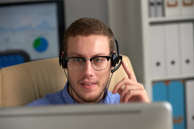 Male hot line operator working in call centre with headset