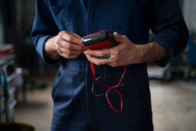 Free photo male mechanic holding repairing equipment