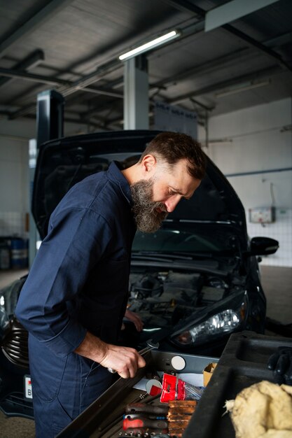 Male mechanic working in auto repair shop on car