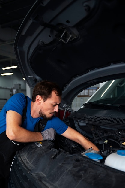 Free Photo male mechanic working on car in the auto repair shop