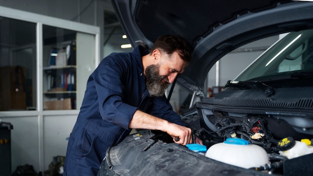 Free Photo male mechanic working on car in the auto repair shop