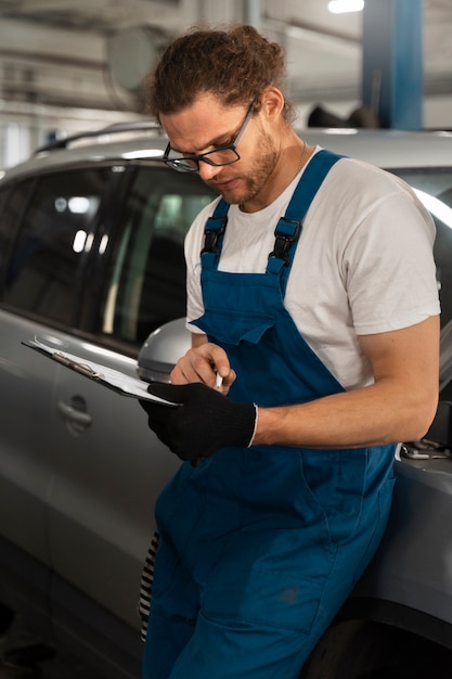 Male mechanic working in the shop on a car