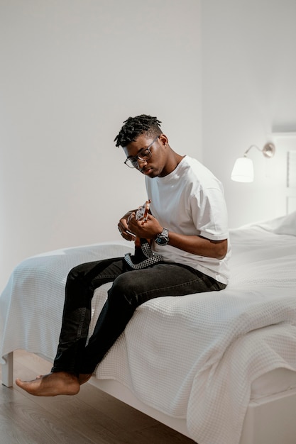 Male musician playing electric guitar on bed