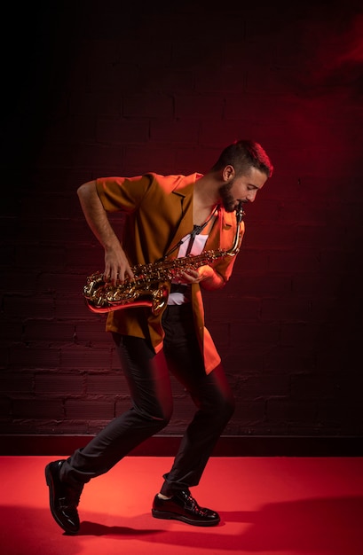 Free photo male musician playing the saxophone in fog with copy space