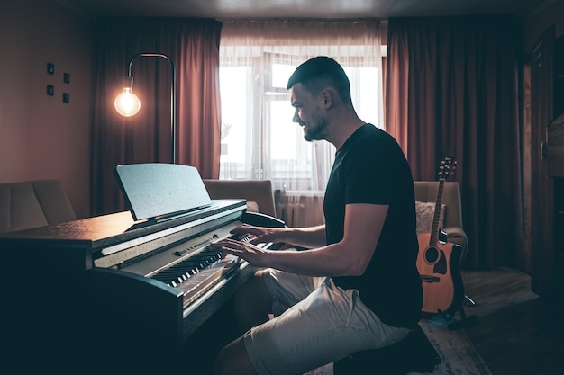 Free photo male musician plays the electronic piano in the room