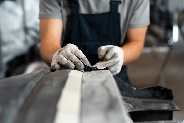 Free Photo male painter in overalls doing his work at the car shop