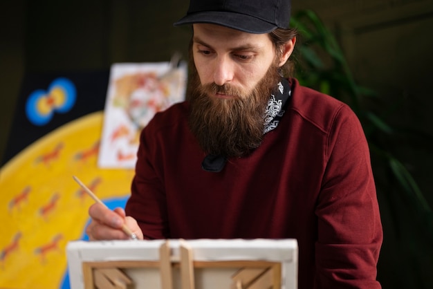 Free Photo male painter in the studio using watercolor on his art