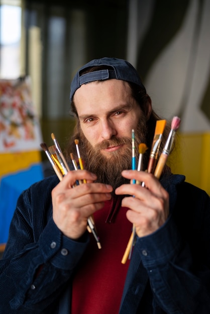 Free Photo male painter in the studio using watercolor on his art