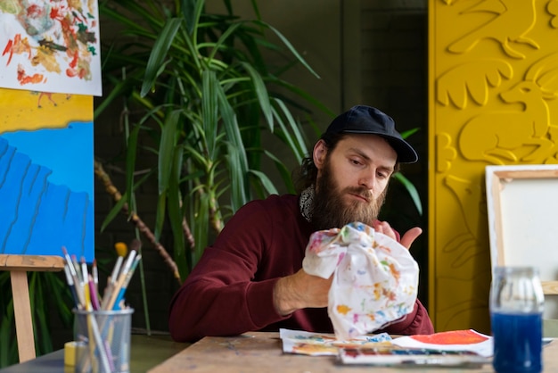 Free Photo male painter using watercolor on his art in the studio