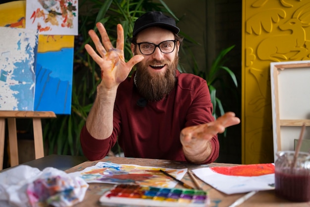 Free photo male painter using watercolor on his art in the studio