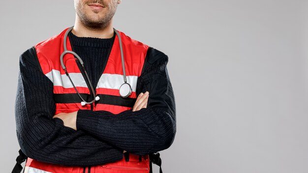 Male paramedic with crossed arms and copy space