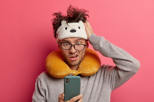 Free photo male passenger wearing inflated travel pillow over neck and cute eye mask