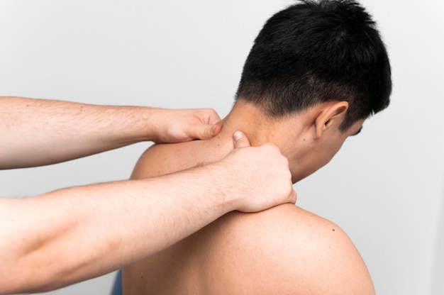 Male patient getting neck massage from physiotherapist