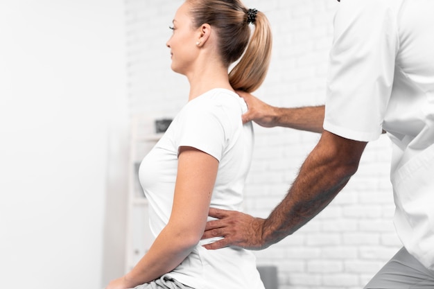 Free photo male physiotherapist checking woman's back