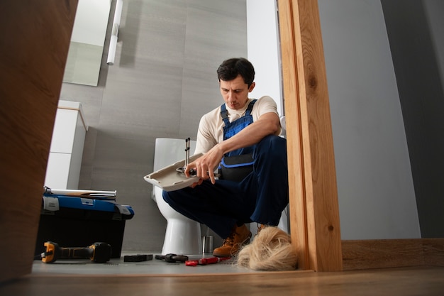 Free Photo male plumber working to fix problems at client's house