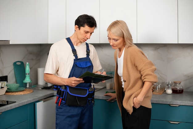 Free photo male plumber working with client to fix kitchen problems