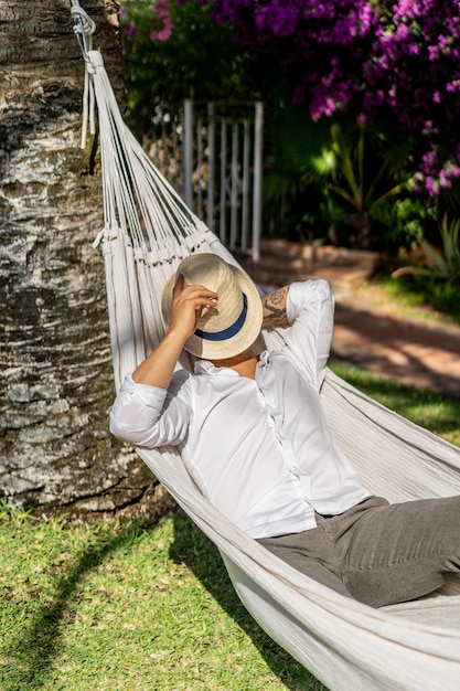 male relaxing in a hammock in the garden.