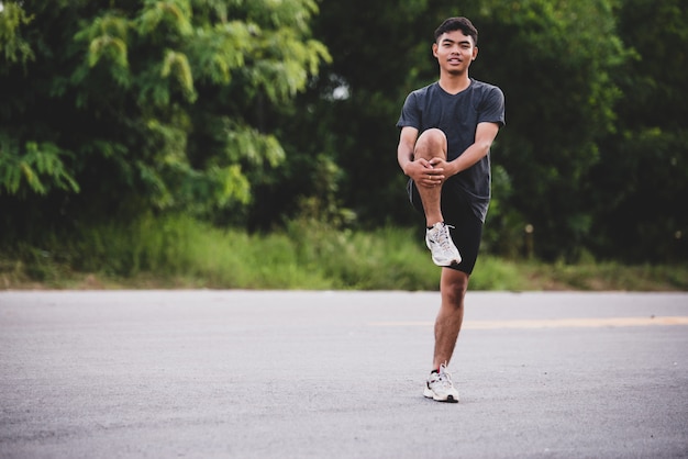 Male runner doing stretching exercise, preparing for workout