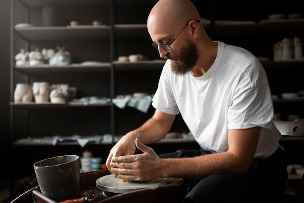 Free Photo male sculptor working with clay in the studio