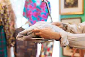 Free photo male seller checking fabric weight on scales at clothing shop