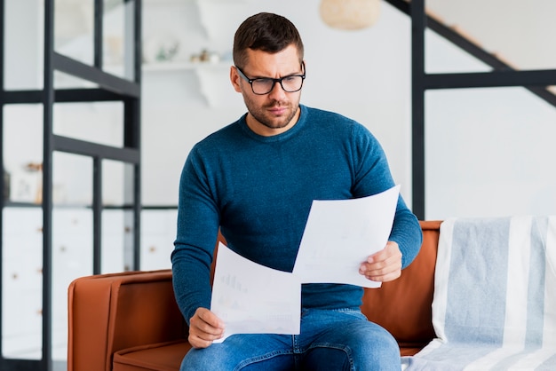 Male sitting on cauch and reading documents