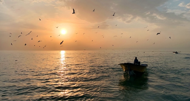 Free photo male in a small rowboat in the middle of the beautiful sea with the sun shining