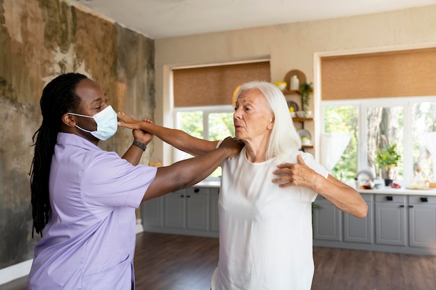 Male social worker taking care of an old woman