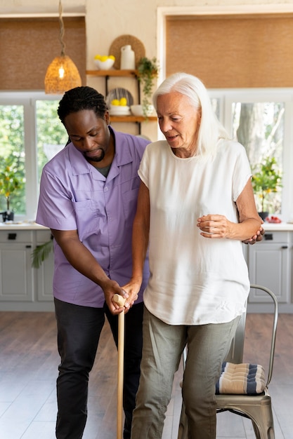 Male social worker taking care of an old woman