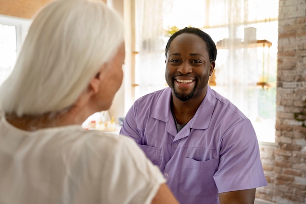 Male social worker taking care of an old woman