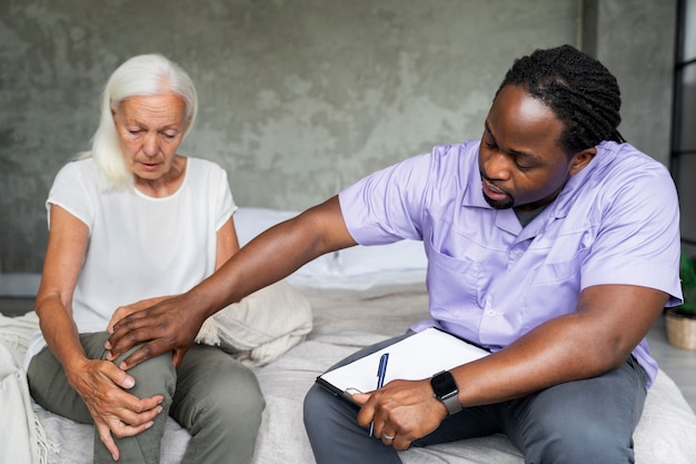 Male social worker taking care of an old woman