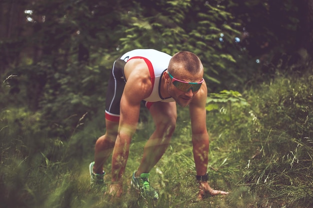 Free Photo male in sportswear and sunglasses running in the forest.