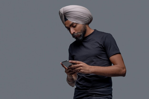 Male staring at the cellphone in his hands