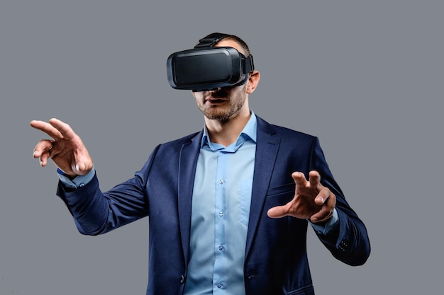 Free photo male in a suit with virtual reality glasses on his head. isolated on grey background.