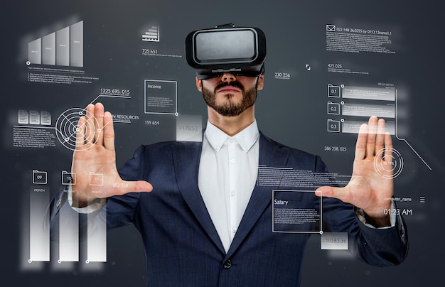 Free photo male in a suit with virtual reality glasses on his head working in virtual financial world.