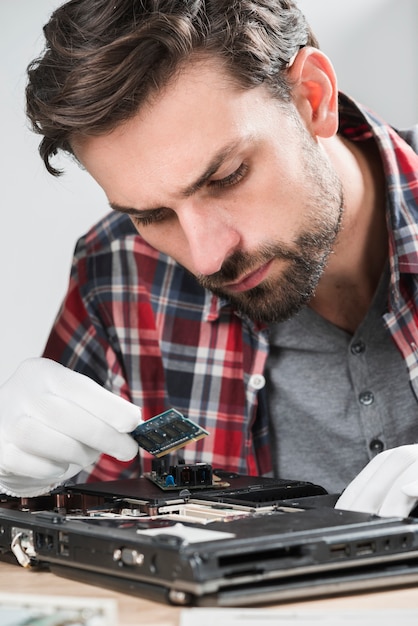 Free photo male technician examining laptop ram