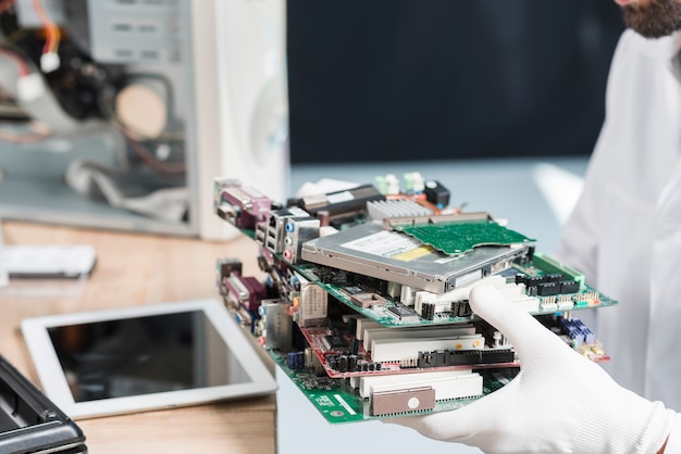 Free photo male technician hand wearing gloves holding computer parts