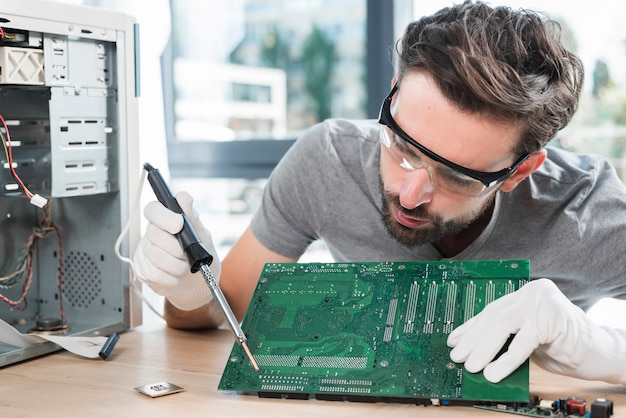 Free photo male technician repairing computer circuit board