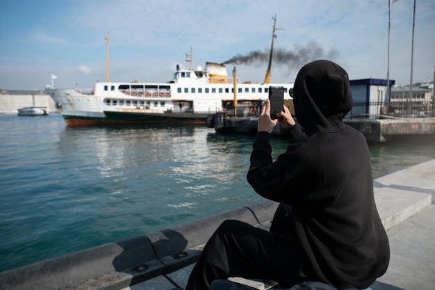 Free photo male tourist taking photos with smartphone during trip