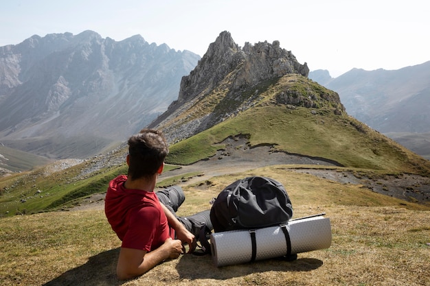 Free photo male traveler hiking on mountains while having his essentials in a backpack