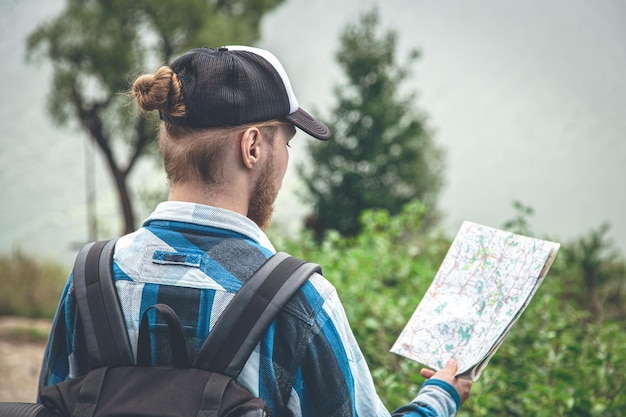 Free Photo male traveler looking at the map hiking concept