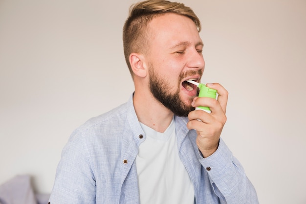 Free photo male using spray for sore throat