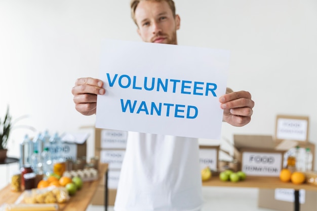 Free Photo male volunteer holding blank paper with information