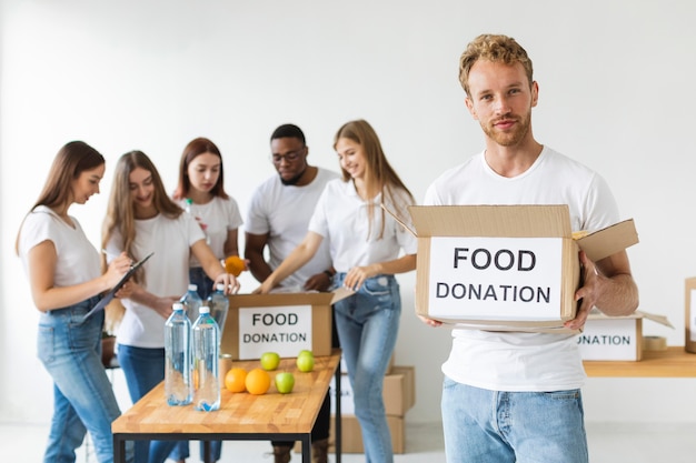 Free photo male volunteer holding food donations