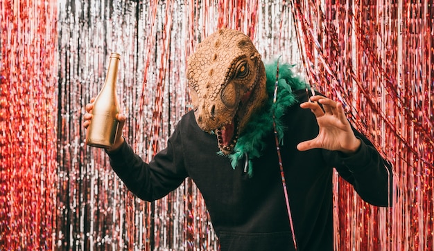 Male with champagne bottle in dinosaur costume