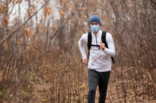 Male with face mask running in the woods