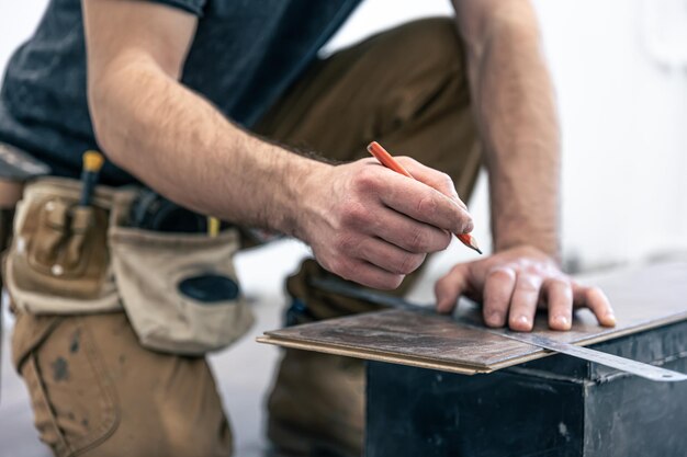 A male worker puts laminate flooring on the floor