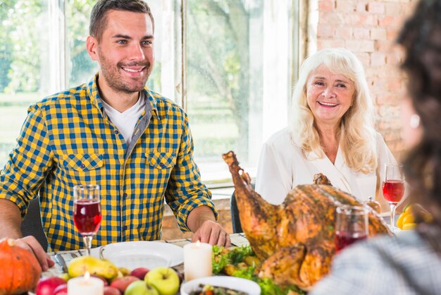 Free photo man and aged woman sitting at table