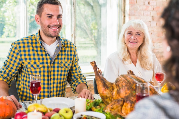 Free Photo man and aged woman sitting at table